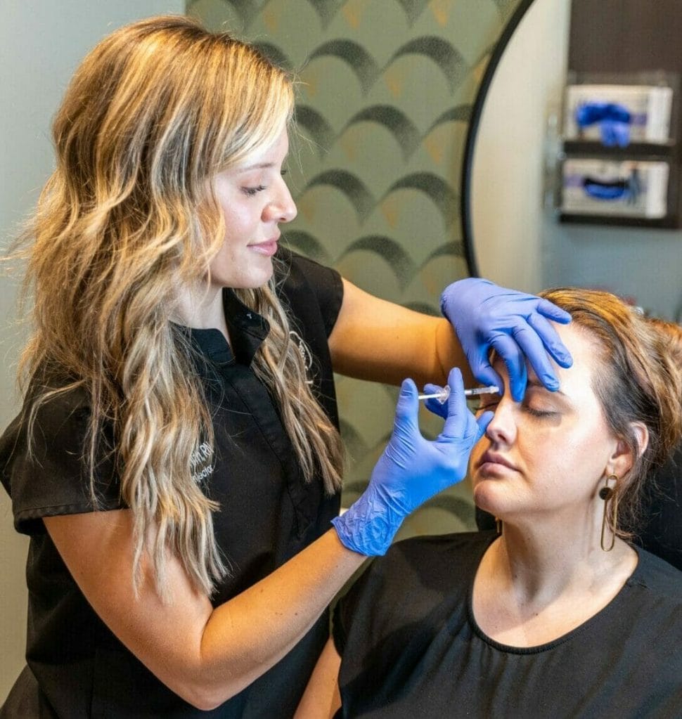 A woman is getting her eyebrows shaped with Tox in a salon.