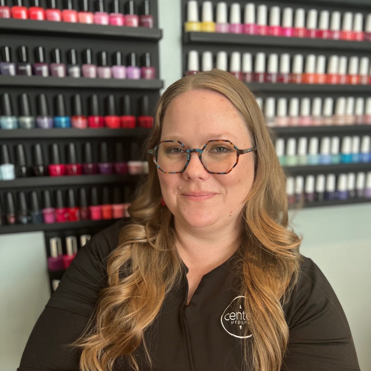 A woman examining a display of nail polishes.