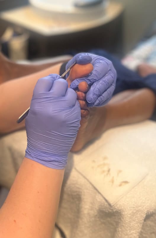 A person receiving a relaxing spa pedicure in a hospital room.