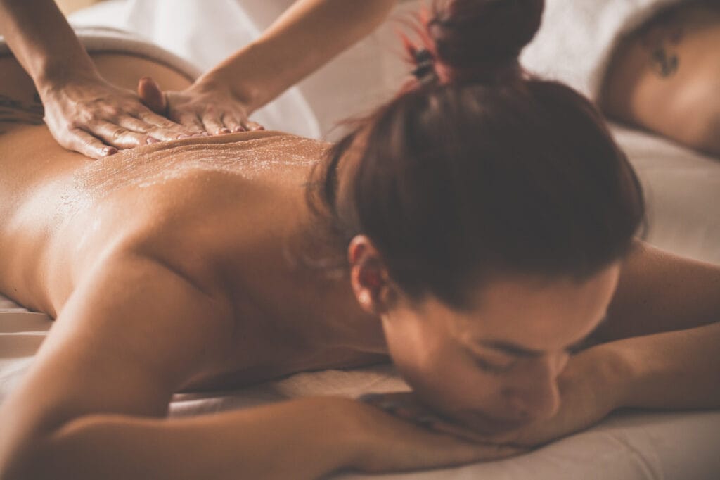 A woman receiving a massage for her back at a spa.