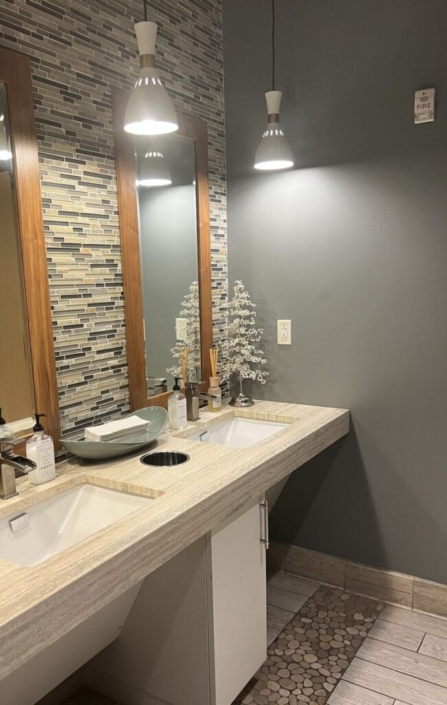 A bathroom with two sinks and a mirror, perfect for pampering your skin.