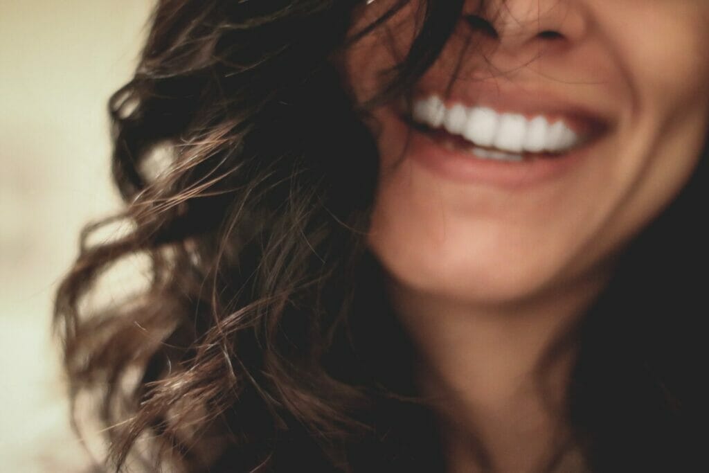 A close up of a woman smiling, leaving you wondering about exosomes.