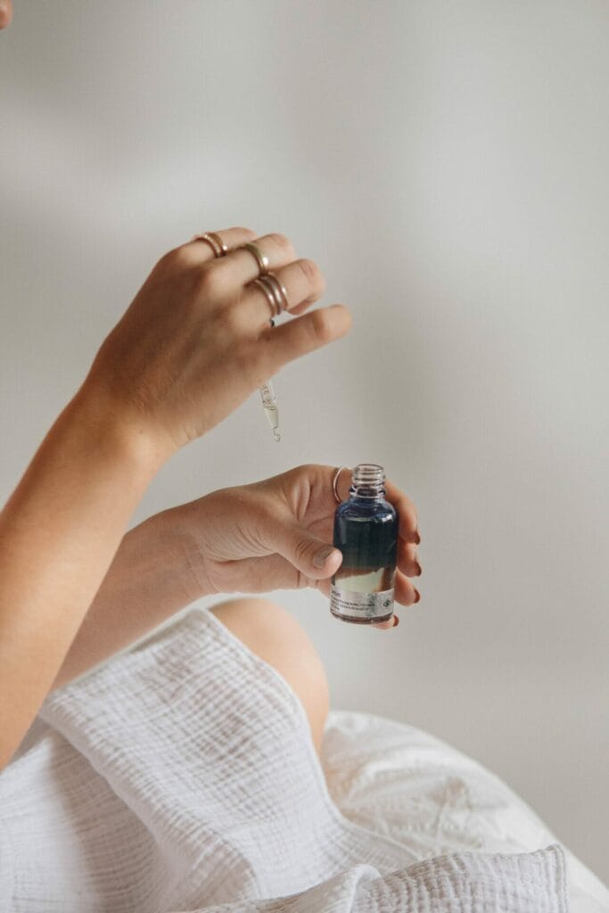 A woman holding a small bottle of exosomes in her hand.