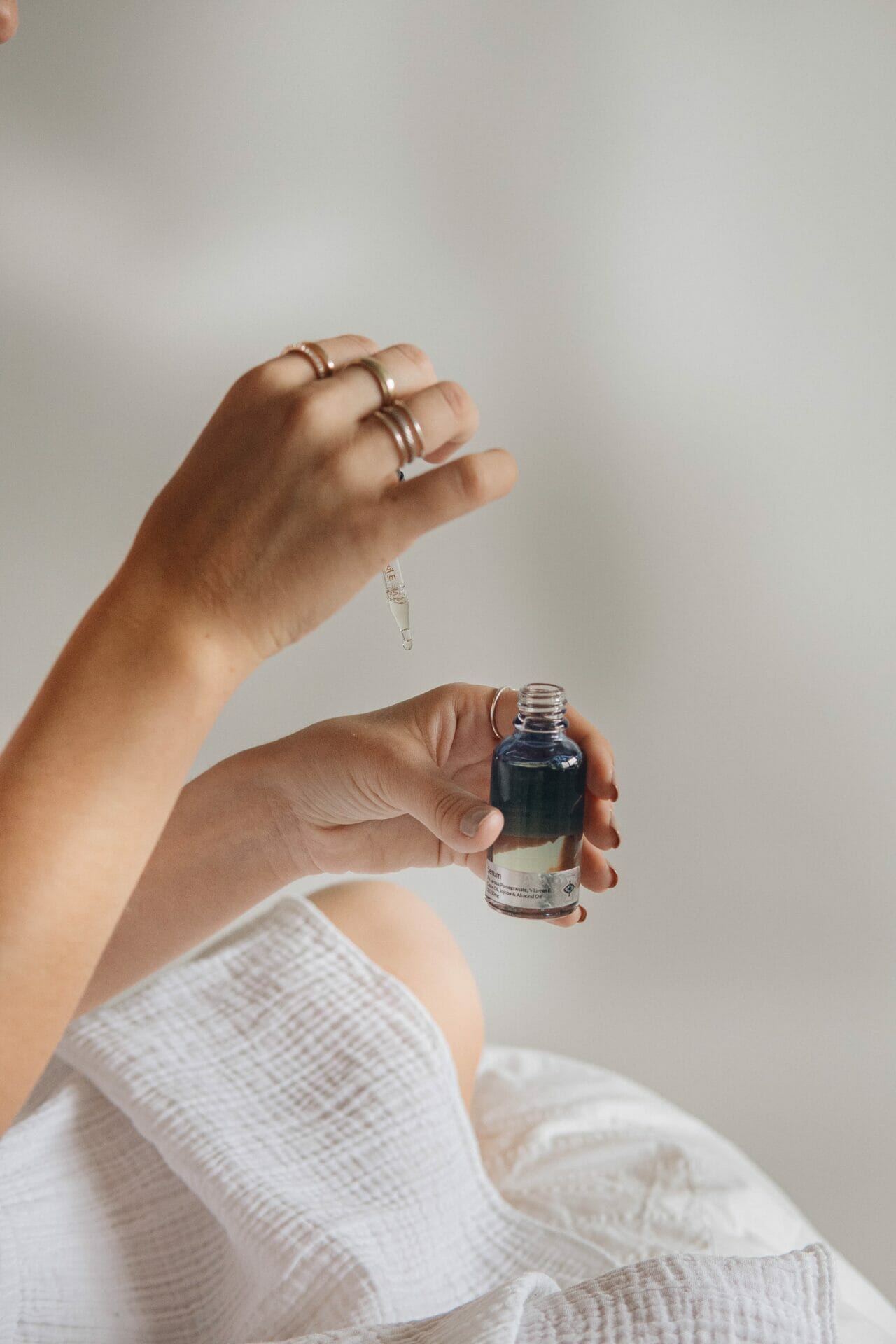 A woman holding a small bottle of exosomes in her hand.