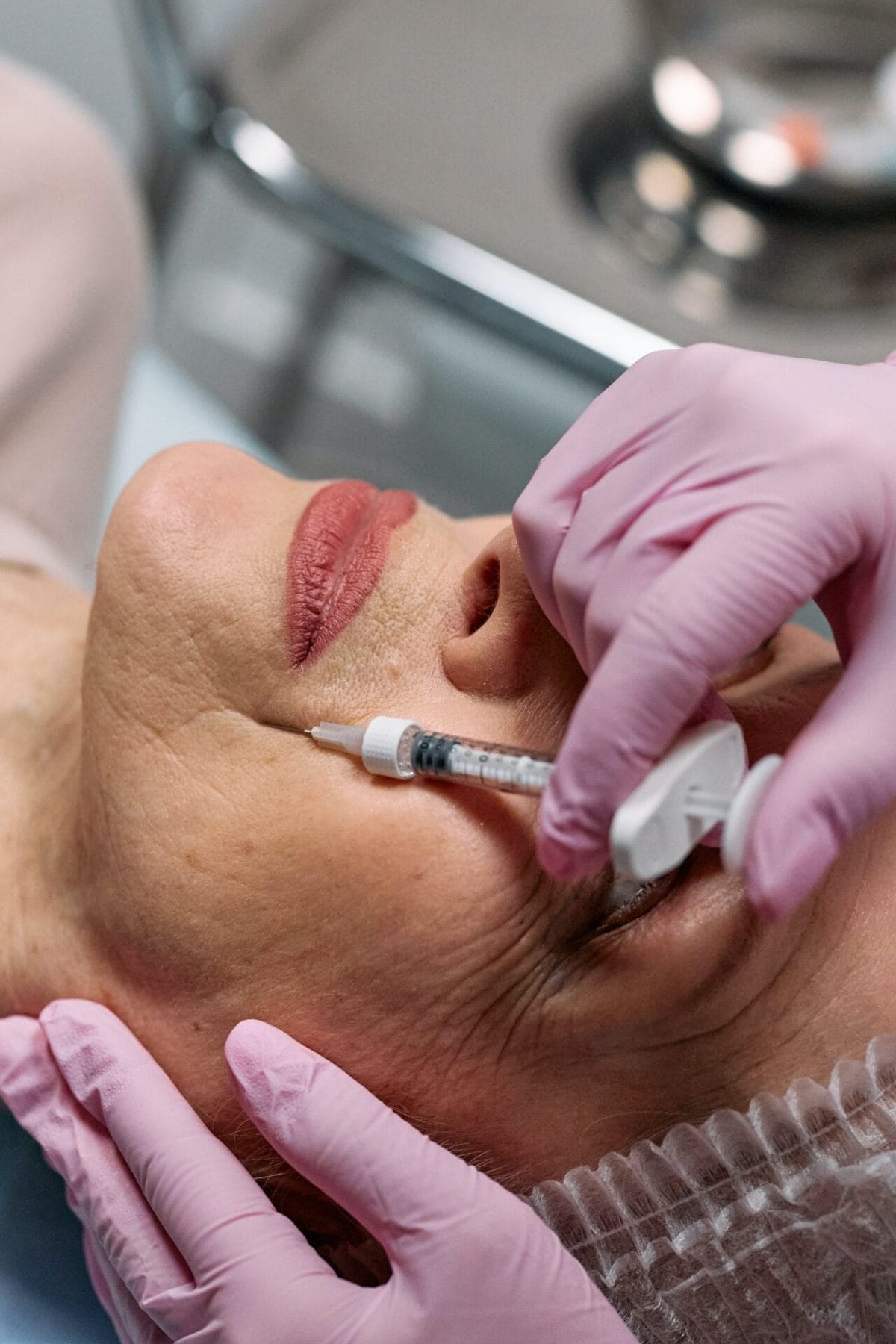 A woman receiving a cosmetic facial injection at a medspa clinic.