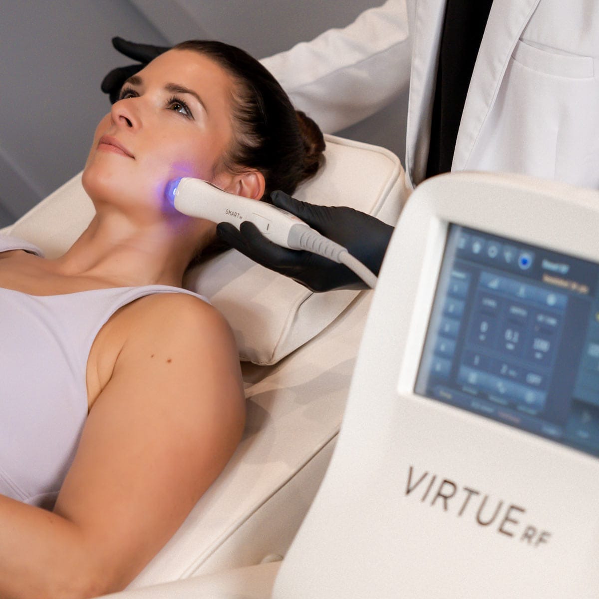A woman is receiving a cutting-edge Virtue Exact RF Microneedling skin treatment on her face.