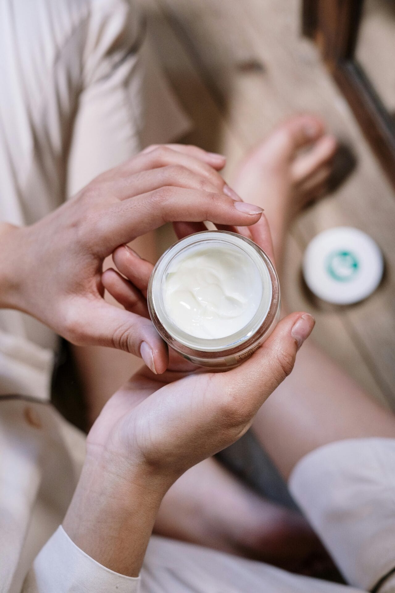 A woman is preventing dry skin by holding a jar of cream during winter.